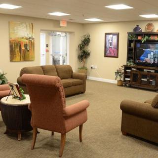 A cozy living room with sofas, a television, and decorative artwork.