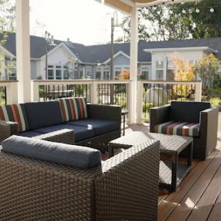 A cozy outdoor seating area featuring stylish furniture, perfect for enjoying the sun.