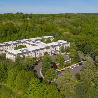 Aerial view of a large building surrounded by lush greenery.