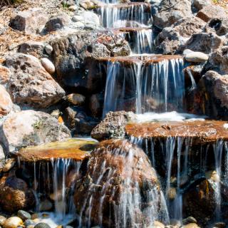 A small waterfall cascading over rocks in a natural setting.