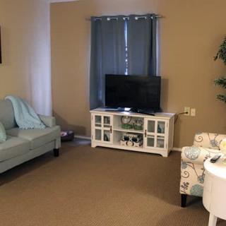 A cozy living room with a TV, sofa, and stylish decor.