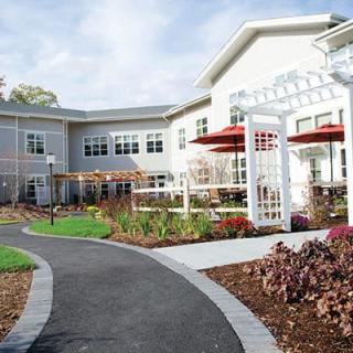 A well-landscaped residential building with a garden and pathway.