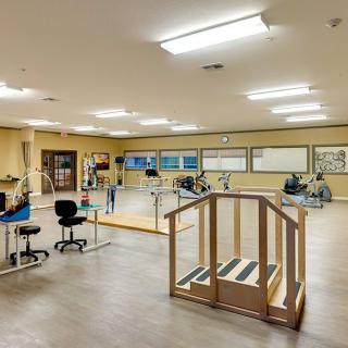 A spacious rehabilitation center equipped with various exercise and physical therapy equipment.