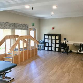 A spacious physical therapy room equipped for rehabilitation exercises.