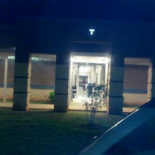 A view of a brightly lit entrance of a building at night.