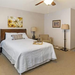 A cozy bedroom with a neatly made bed, two lamps, and tasteful decor.