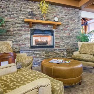 A cozy living room with a stone fireplace and comfortable seating.