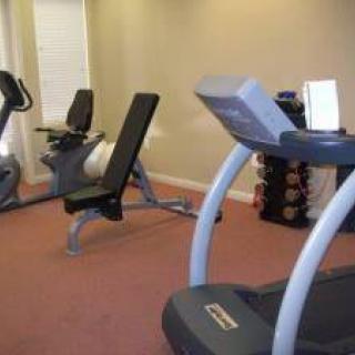 A gym with fitness equipment including a treadmill, exercise bike, and weights.