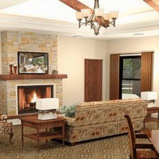 A cozy living room featuring a fireplace, a comfortable sofa, and elegant lighting.