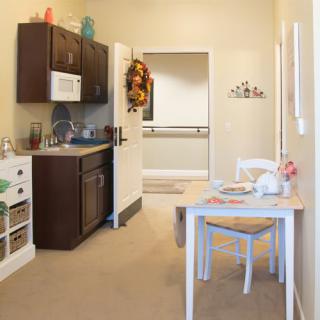 A cozy kitchen with a small dining table and chairs, featuring modern decor and appliances.