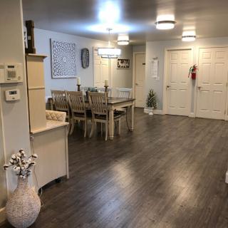 A modern dining area featuring a large table with chairs, stylish lighting, and sleek hardwood flooring.