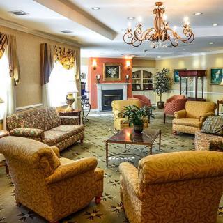 A cozy and elegantly decorated living room with comfortable seating and a chandelier.