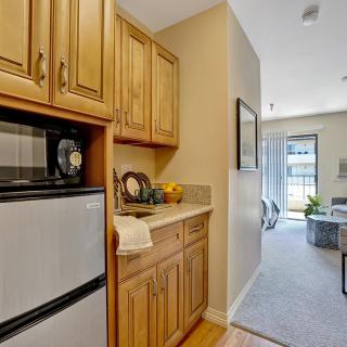 A cozy home interior featuring a kitchen area with wooden cabinets and an open view into the living room.