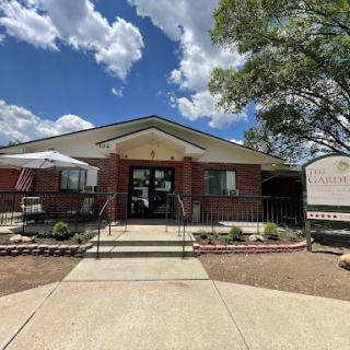 A welcoming entrance featuring a well-maintained building under a clear blue sky.