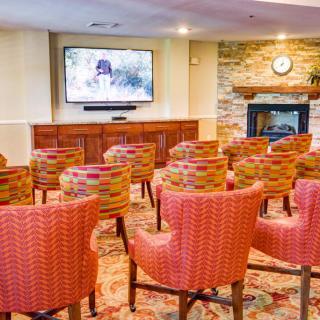 A cozy conference room with a television and multiple rows of chairs.