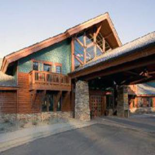 A rustic log cabin with wooden architecture and stone accents.