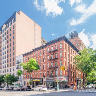 A bustling street corner with classic urban architecture and vibrant city life.