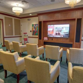 A cozy room with comfortable chairs arranged facing a television screen.