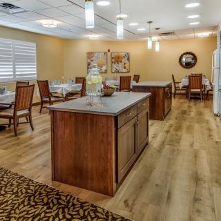 A well-lit dining room with wooden tables and chairs, featuring elegant interior design and decor.