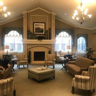 A cozy living room with elegant chandeliers and a warm fireplace.