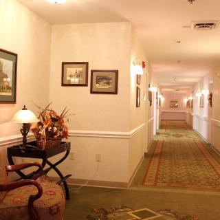 A well-lit hotel hallway with decorative elements and artwork on the walls.