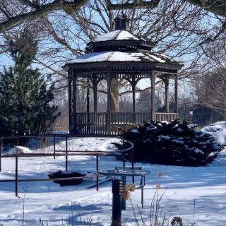 A snow-covered gazebo in a winter park.