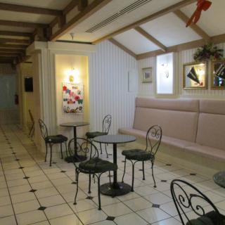 A cozy cafe interior with metal tables and chairs on a tiled floor.