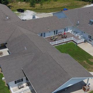 Aerial view of a large residential building with a well-maintained lawn.