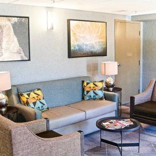 A modern living room with stylish furniture, artwork, and decorative lamps.