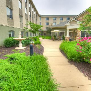 A well-landscaped garden path leading to a building entrance.