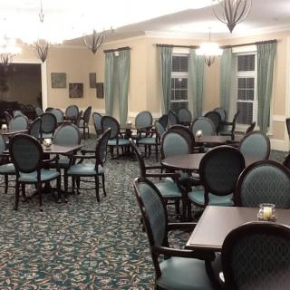 An empty dining room with neatly arranged tables and chairs, featuring elegant interior design.