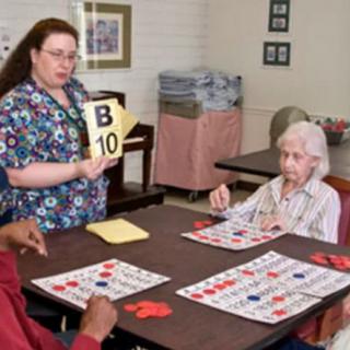 A group of people playing bingo at a nursing home.