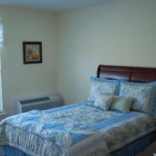 A cozy bedroom with a neatly made bed and decorative pillows.