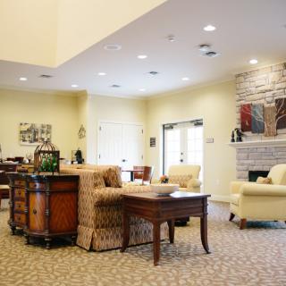 A cozy living room interior featuring comfortable sofas, a wooden table, and a fireplace.