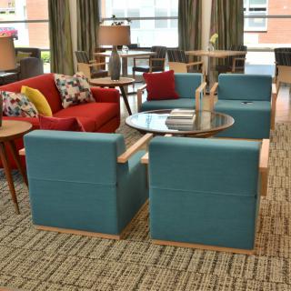 A modern living room interior with colorful sofas and a glass coffee table.