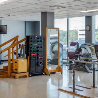 A rehabilitation center with exercise equipment, including stairs and treadmills.