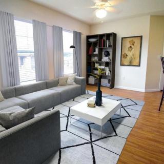 A modern living room with a gray sofa, stylish coffee table, and a well-organized bookshelf.