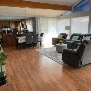 A spacious, open-concept living and dining area with hardwood flooring and modern furnishings.