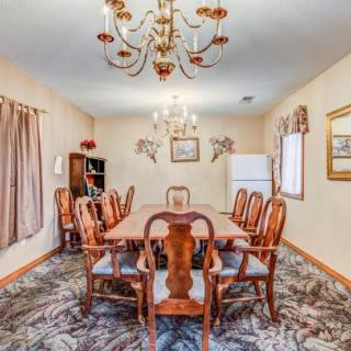A traditional dining room with elegant wooden furniture, a chandelier, and decorative artwork.
