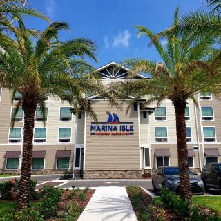 A modern hotel building with palm trees against a clear blue sky.