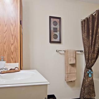 A neatly arranged bathroom with a sink, mirror, and shower curtain.