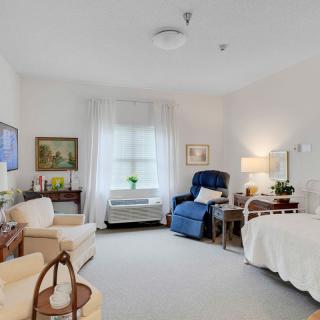 A cozy and well-furnished bedroom with a bed, reclining chair, and various decorative elements.