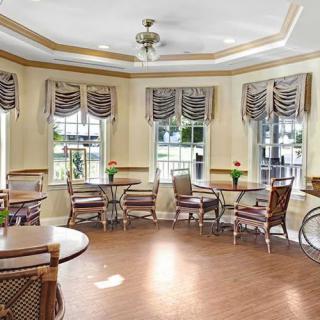 A cozy dining room with elegant furniture and large windows.