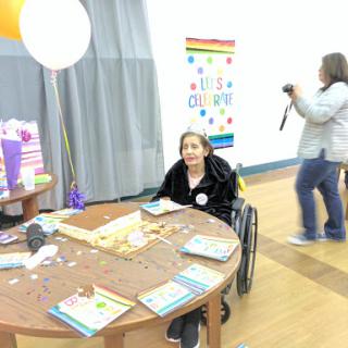 A gathering featuring craft activities, with a participant in a wheelchair at the table.