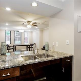 Modern kitchen with granite countertops and open living area.