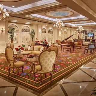A luxurious hotel lounge area with elegant furniture and a grand piano.