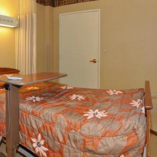 A simple bedroom setup with a bed and small table.