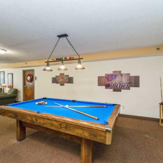 A cozy game room with a blue-felt pool table and stylish lighting.