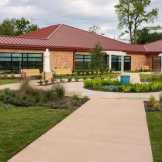 A modern building with a landscaped garden and walkway.