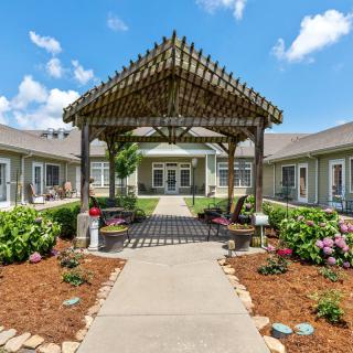 A beautifully landscaped courtyard featuring a pergola and vibrant garden.